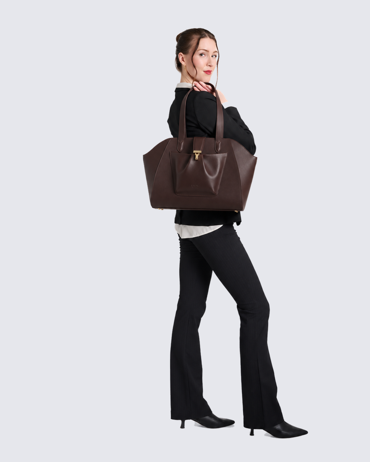 The Fiora Tote Travel Edition in Dark Brown, on the shoulder