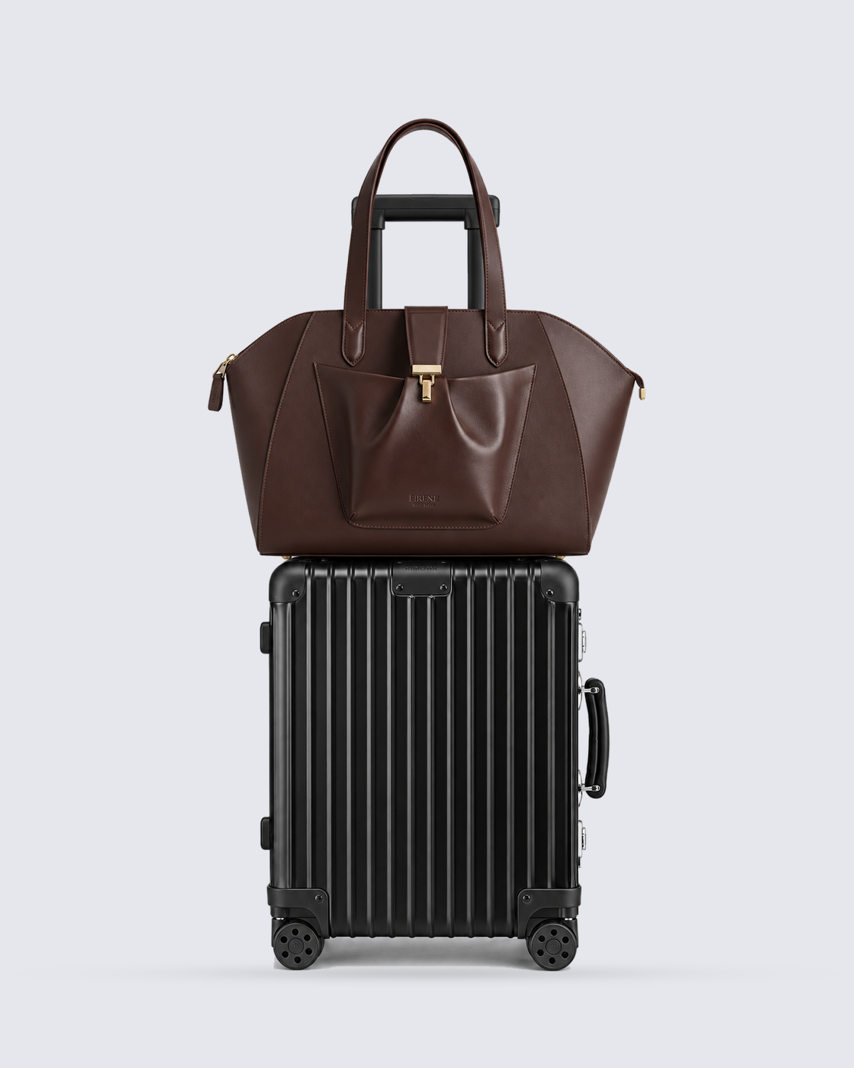 The Fiora Tote Travel Edition in Dark Brown, on a trolley, front